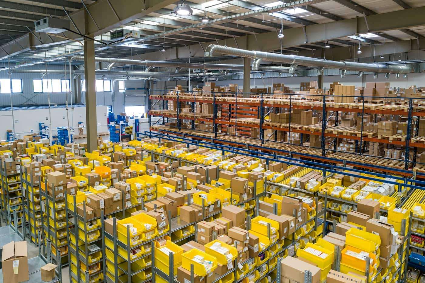 A bright warehouse with rows of boxes on tall shelves.